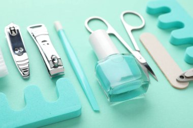 Turkuaz arka planda farklı manikür araçları seti, yakın plan