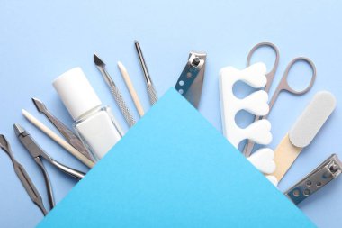 Açık mavi zemin üzerinde farklı manikür araçları seti, düz yatıyordu. Metin için boşluk