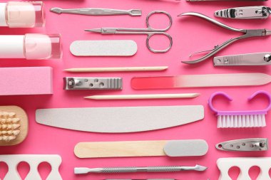 Parlak pembe arka plan üzerinde farklı manikür araçları, düz yatıyordu