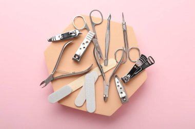 Pembe arka planda farklı manikür araçları, düz yatış