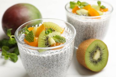 Kivili lezzetli chia pudingi, beyaz masada şeftali ve nane şekeri, yakın plan.