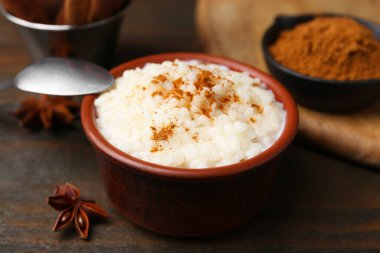 Tahta masada servis edilen tarçınlı lezzetli sütlaç, yakın plan.