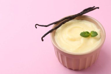 Lezzetli vanilyalı puding, nane ve kapsüller pembe arka planda, yakın plan. Metin için boşluk