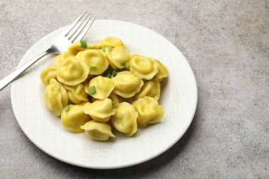 Gri desenli masada yeşil soğan ve çatallı lezzetli börekler. Metin için boşluk