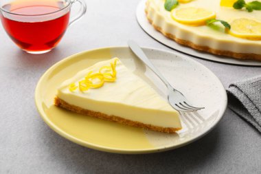 Lezzetli limonlu cheesecake ve çatal gri desenli masa, yakın plan.