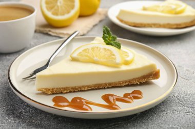 Gri desenli masada servis edilen lezzetli limonlu cheesecake parçaları.