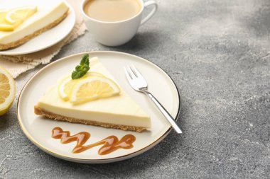 Gri dokulu masada servis edilen lezzetli limonlu cheesecake parçaları, yakın plan. Metin için boşluk