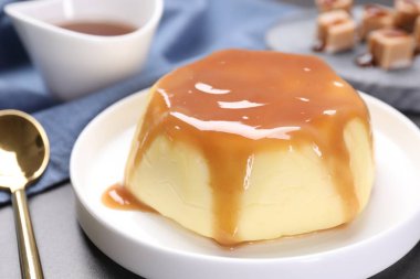 Masada servis edilen karamel soslu lezzetli puding, yakın plan.