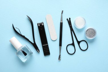 Açık mavi zemin üzerinde farklı manikür araçları kümesi, düz yatıyordu