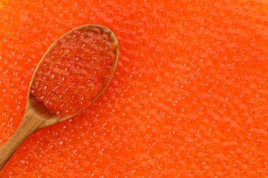 Arka plan olarak lezzetli kırmızı havyar ve kaşık, yakın görüntü