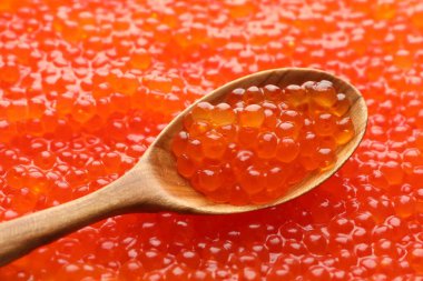 Arka plan olarak lezzetli kırmızı havyar ve kaşık, yakın plan