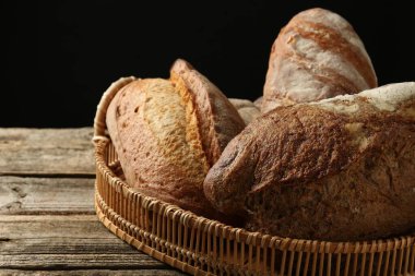 Tahta masadaki sepetin içinde farklı somunlar, yakın çekim.