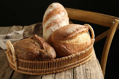 Tahta masadaki sepetin içinde farklı somunlar, yakın çekim.