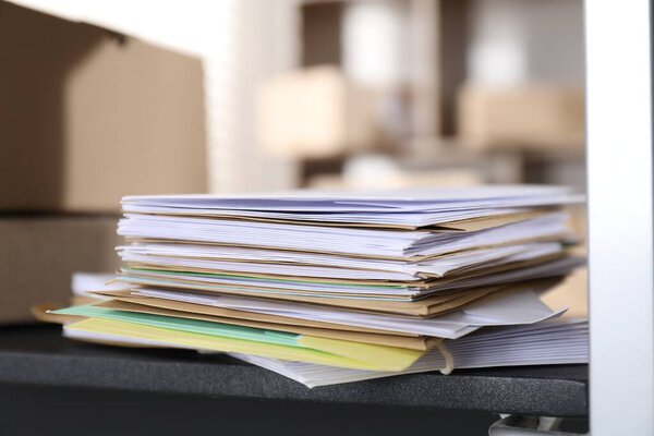 Много разных конвертов на полке в почтовом отделении