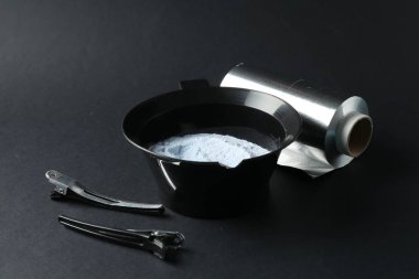 Beyazlatma tozu ve kuaför aletleri siyah arka planda, yakın plan