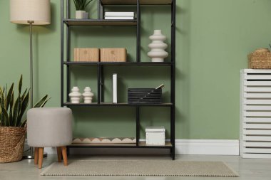 Salon içinde zeytin duvarının yanında farklı dekorasyonu olan ahşap raf ünitesi.