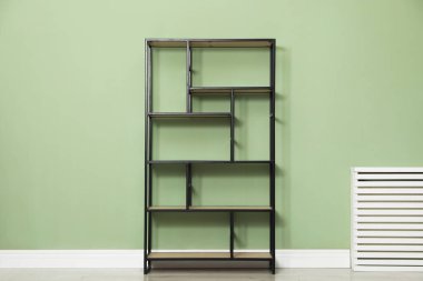 İçerideki zeytin duvarının yanındaki boş ahşap raf ünitesi.