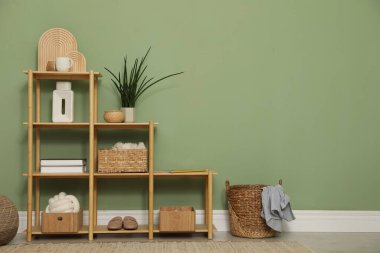 İçerideki zeytin duvarının yanında farklı dekorasyonu olan ahşap raf ünitesi. Metin için boşluk