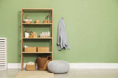 İçerideki zeytin duvarının yanında farklı dekorasyonu olan ahşap raf ünitesi. Metin için boşluk