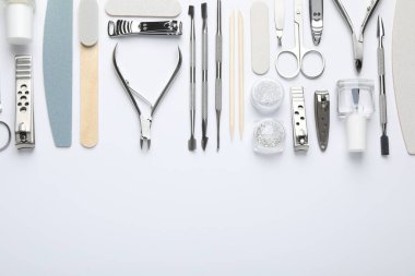 Beyaz arka planda farklı manikür aletleri var. Metin için boşluk