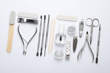Beyaz arkaplanda farklı manikür araçları kümesi, düz yatıyordu