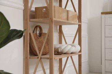 Beyaz duvarın yanında dekorasyonu olan şık raf ünitesi.