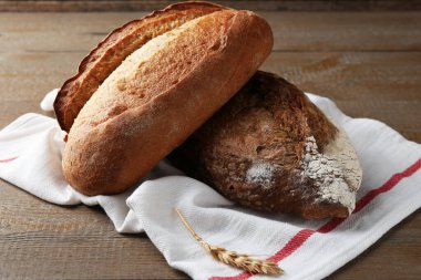 Taze pişmiş somunlar ve çiviler ahşap masada, yakın plan.