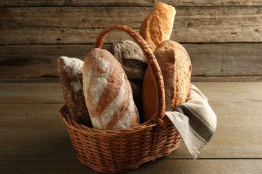 Tahta masadaki hasır sepette farklı somunlar.