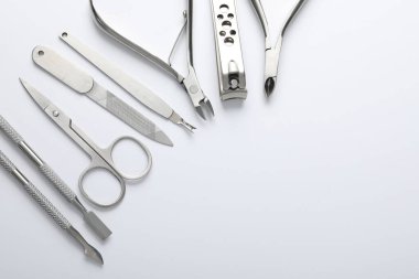 Beyaz arka planda farklı manikür aletleri var. Metin için boşluk