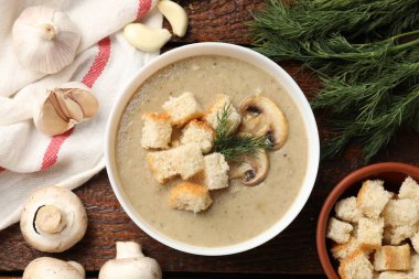 Lezzetli mantar kremalı çorba, kızarmış ekmek, dereotu ve malzemeler ahşap masada, düz yerde.