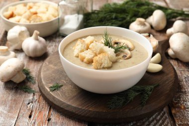 Lezzetli mantar kremalı çorba, kızarmış ekmek, dereotu ve ahşap masa malzemeleri.