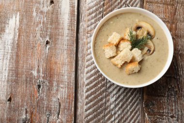 Ekmek arası mantar kremalı çorba ve ahşap masada dereotu, üst manzara. Metin için boşluk