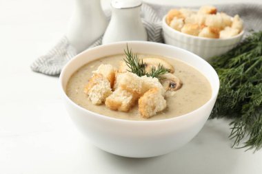 Ekmek arası kremalı leziz mantar çorbası ve dereotu beyaz masada servis edilir.