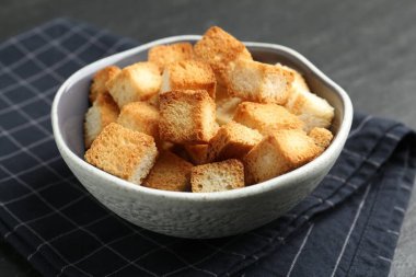 Koyu dokulu masada kasede kıtır kıtır kızarmış ekmek, yakın plan.