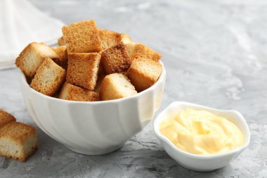 Gri desenli masada çıtır kıtır ekmek ve sos. Yakın plan.