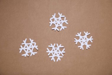 Kahverengi arka planda güzel kar taneleri, düz uzanmış.