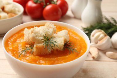 Lezzetli balkabağı kremalı çorba, kızarmış ekmek, dereotu ve ahşap masa malzemeleri, yakın plan.