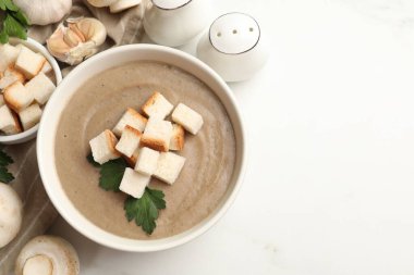 Ekmek arası mantar kremalı çorba, maydanoz ve malzemeler beyaz masada. Metin için boşluk