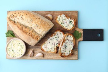 Açık mavi arka planda sarımsaklı, otlu ve tereyağlı lezzetli ekmek.