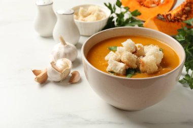 Lezzetli balkabağı kremalı çorba, kızarmış ekmek ve mayonezli beyaz masa, yakın plan.