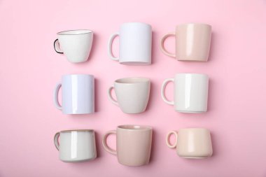 Pembe arka planda bir sürü renkli fincanlar var.