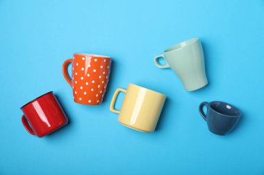 Açık mavi arkaplanda bir sürü renkli fincan, düz yatıyordu.