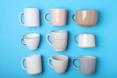 Açık mavi zemin üzerinde birçok farklı fincan, düz yatıyordu