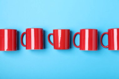 Açık mavi arkaplanda bir sürü renkli fincan, düz yatıyordu.