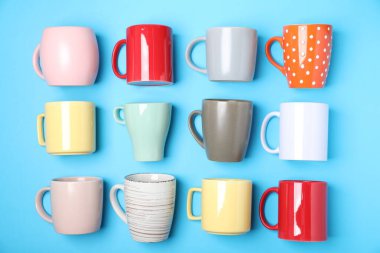 Açık mavi arkaplanda bir sürü renkli fincan, düz yatıyordu.