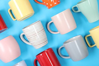 Açık mavi arkaplanda bir sürü renkli fincan, düz yatıyordu.