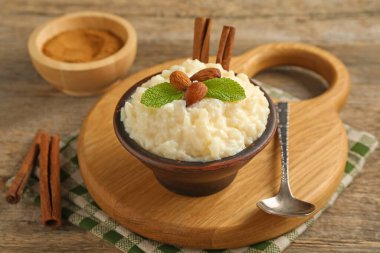 Tahta masada servis edilen bademli, nane ve tarçınlı lezzetli sütlaç, yakın plan.