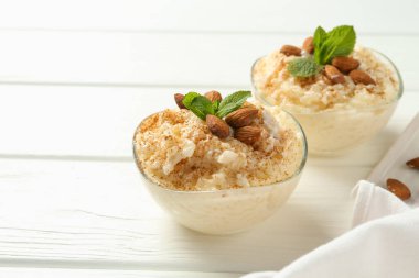 Tarçınlı lezzetli pirinç pudingi, beyaz ahşap masada nane şekeri, yakın plan. Metin için boşluk