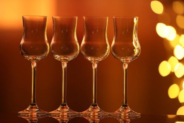 Bulanık ışıklara karşı cam ayna yüzeyinde birçok temiz bardak var. Bokeh etkisi