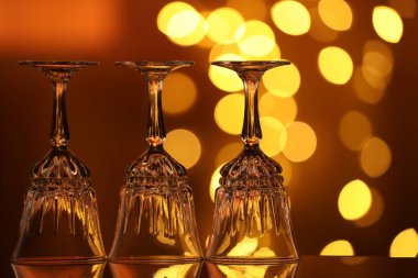 Bulanık ışıklara karşı cam ayna yüzeyinde birçok temiz bardak var. Bokeh etkisi